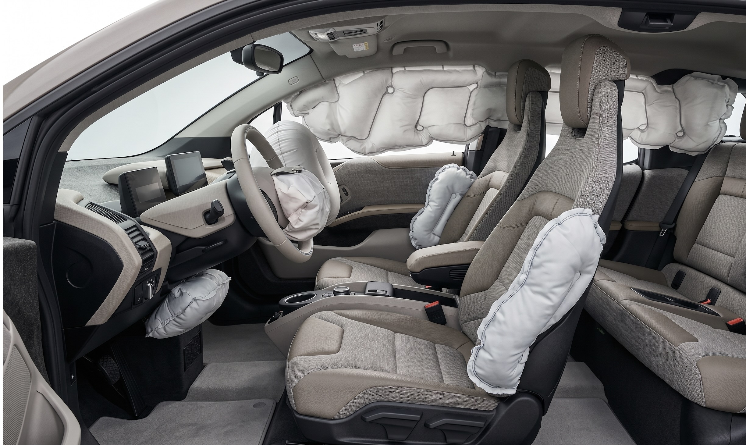 Interior de coche con airbags frontales, laterales y de cortina desplegados