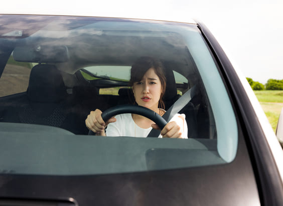 conductora nerviosa con cinturón de seguridad cogiendo fuerte el volante